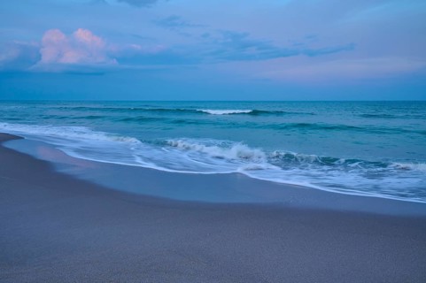 Beach scene with calming waves and blue evening sky, Cocoa Beach, Port Canaveral, Florida, USA