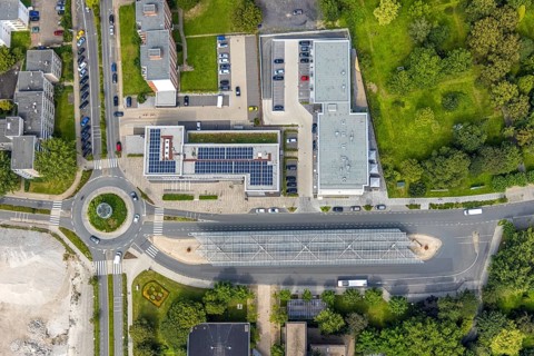 Aerial view, bus station with roundabout and savings bank building with solar roof in Schönhausen,