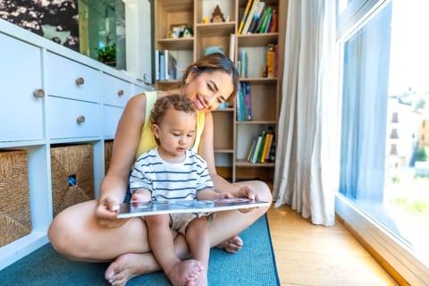 Happy mother and son enjoying quality time together, sitting on the living room floor, engrossed in