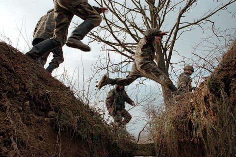 BIH, Bosnia, Brcko, 07.01.1996, Bosnian and American soldiers jump over a former trench
