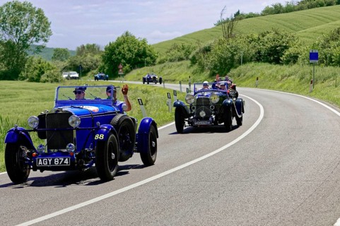 Two blue classic cars driving one behind the other on a winding country road, classic car, car