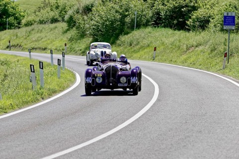 A purple vintage car followed by a white car on a country road, vintage car, car race, Mille