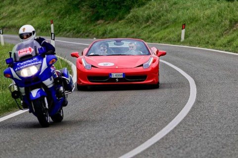 Blue motorbike overtakes red Ferrari convertible on winding road, classic car, car race, Mille