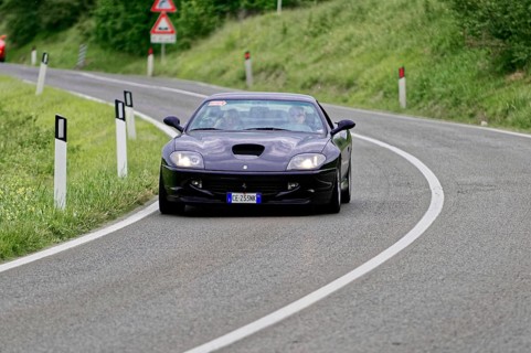 Dark blue sports car on a winding road in a rural setting, classic car, car race, Mille Miglia,