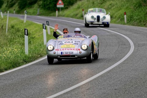 Silver classic car on country road, two people waving from the vehicle, classic car, car race,
