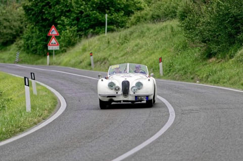 Classic car in white colour drives on winding country road, classic car, car race, Mille Miglia,