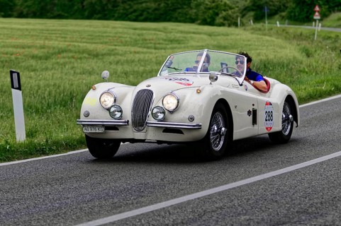 White retro convertible on country road with two people, classic car, car race, Mille Miglia, 1000