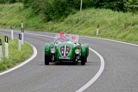 Green classic car driving on a winding country road, classic car, car race, Mille Miglia, 1000