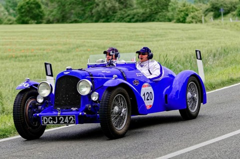Two people in a blue vintage car on a country road, vintage car, car race, Mille Miglia, 1000