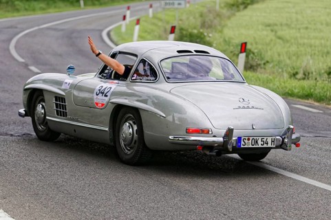 Silver retro sports car turns off on a winding road, classic car, car racing, Mille Miglia, 1000