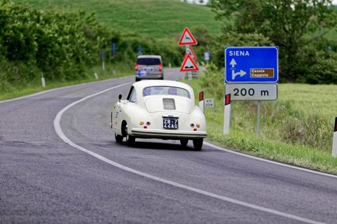 White retro limousine with traffic signs and green landscape, classic car, car race, Mille Miglia,