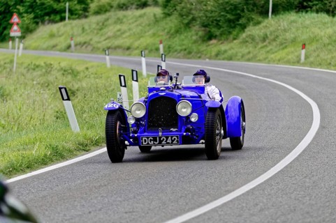 Blue vintage racing car with two people on a country road, classic car, car race, Mille Miglia,