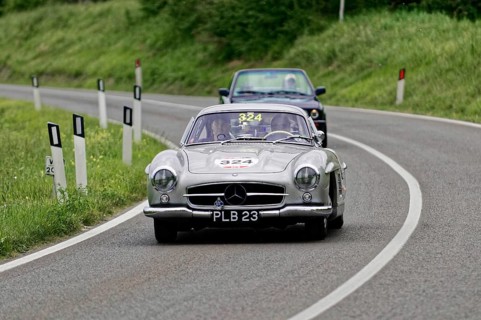 Silver classic car on a winding, rural road accompanied by a blue car, classic car, car race, Mille