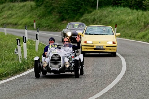 Classic racing car with yellow car in the background on country road, classic car, car race, Mille