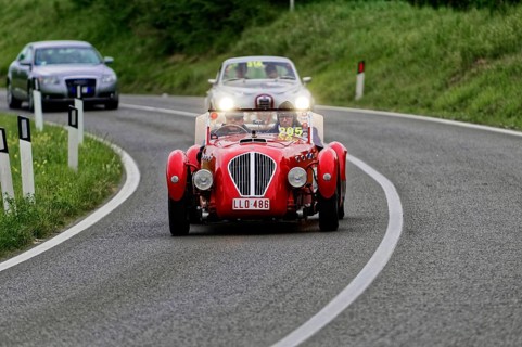 Red classic car on a winding country road at dusk, classic car, car race, Mille Miglia, 1000