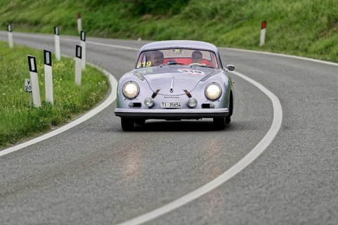 Silver classic car on a winding road through green hills, classic car, car race, Mille Miglia, 1000