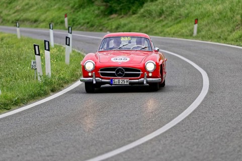 A classic red Mercedes vintage car on a winding country road, classic car, car racing, Mille