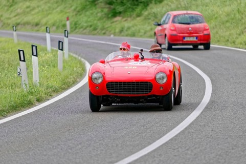Red Ferrari vintage convertible on a winding country road during a race, vintage car, car race,