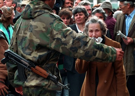 BIH, Bosnia, Sarajevo, 16.09.1992, woman is held back by a bus evacuating people from Sarajevo