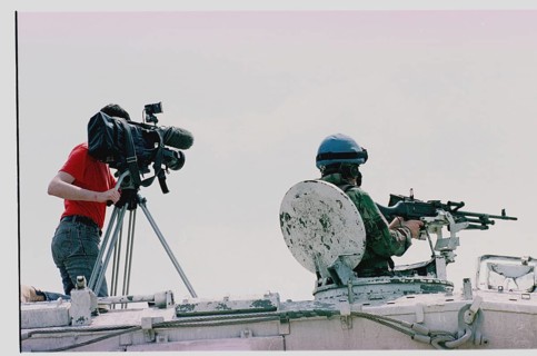 BIH, Tuzla, 01.05.1993 -- A cameraman and a British UN soldier wait for refugees from Srebrenica to