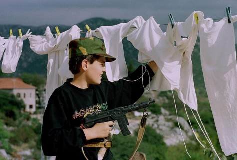 HRV, Kraotien, Dubrovnik 20.09.1993 Child with toy gun behind laundry. HRV Croatia, Dubrovnik, 1993