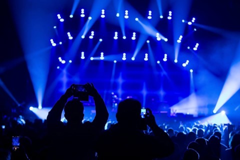Two concertgoers photograph Sting (civil: Gordon Matthew Thomas Sumner, CBE) live with their mobile