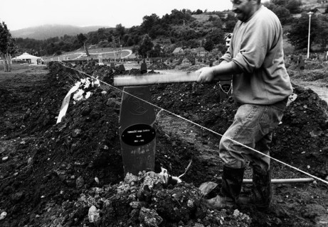 BIH, Bosnia, Screbrenica, 10.07.2005, Man punches a Muslim grave cross into the ground