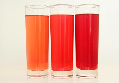 Three glasses of red and transparent liquid on white background, São Paulo, Brazil