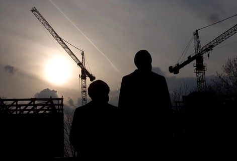 The statues of Marx and Engels stand against cranes demolishing the Palace of the Republic