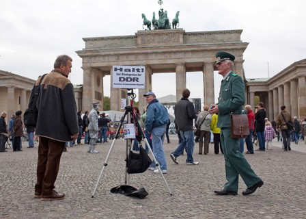 DEU Germany Berlin fundraisers in GDR uniform with a state border sign. The Lord collects donations