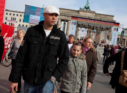DEU Germany Berlin People stroll in front of the Brandenburg Gate. Scene on the eve of the 20th