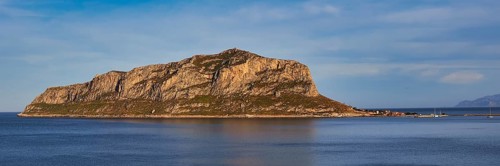 Massive rocky island juts out of the still sea in the afternoon, Monemvasia, Monemvassia, Malvasy,