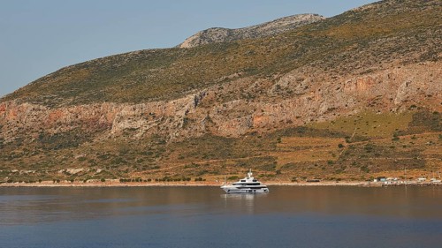 Yacht on calm water in front of a landscape with rocky mountains, Monemvasia, Monemvassia, Malvasy,
