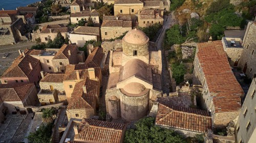 Drone view, aerial view of a compact church structure with domed roof, surrounded by traditional