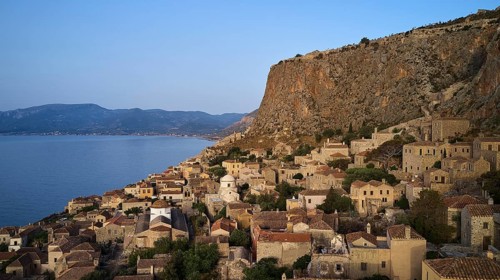 Drone shot, steep cliff with traditional village architecture and sea view, Monemvasia,