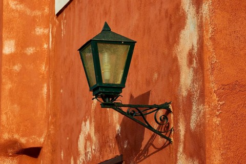 A green lantern hangs on a rust-tinted wall with distinct texture, Monemvasia, Monemvassia,