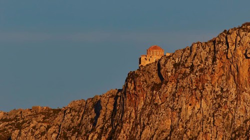 Orhodox church of Hagia Sophia, chapel high on a rock, illuminated in orange evening light,