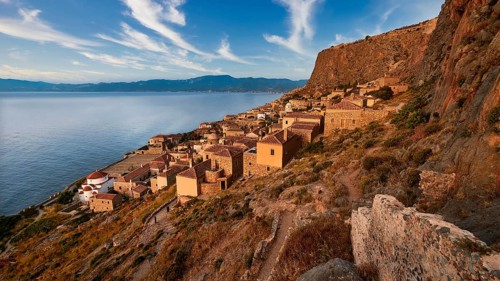 Sky replaced, traditional coastal village with stone houses on a steep rocky coast, Monemvasia,