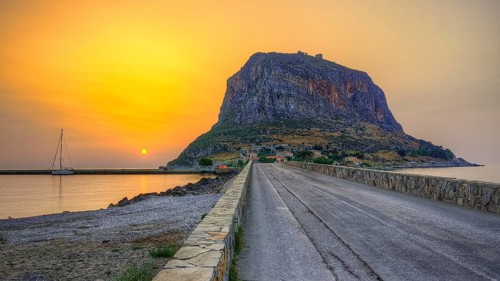 HDR road leads to an imposing mountain by the sea in the soft light of sunrise, Monemvasia,