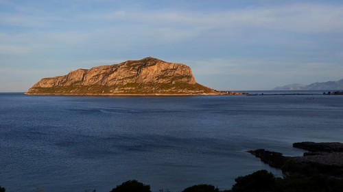 Flat rocky island in the calm blue sea under a clear sky, Monemvasia, Monemvassia, Malvasy,
