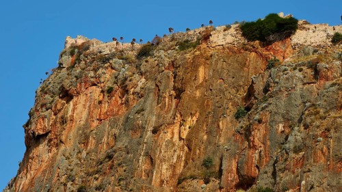 Soft morning light, spectacular cliffs with castle walls and distinct geological layers,
