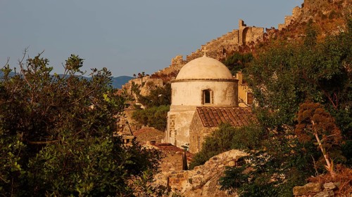 Soft morning light, small church surrounded by ruins and vegetation on a rock at morning light,