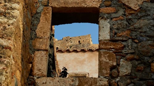 Soft morning light, view through an old window of a ruin with clear blue sky, Monemvasia,