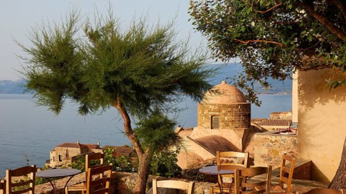 Soft morning light, fresh tree with Mediterranean vegetation and view of the sea from a terrace,