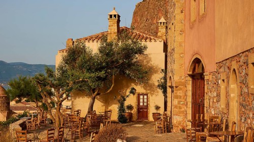 Soft morning light, cozy open-air café with rustic charm and historic buildings at sunrise,