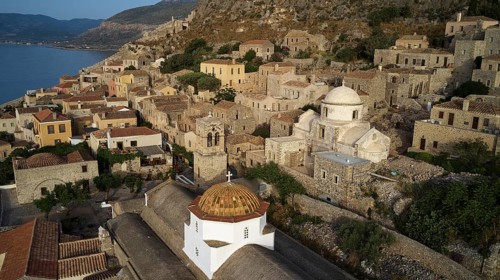 Drone shot, panoramic view of the seaside village with distinctive church dome and ancient