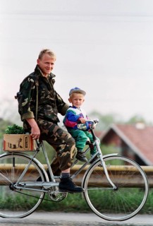 BIH, Bosnia, Tuzla, 23.08.1994 A Bosnian soldier rides a bicycle with his son