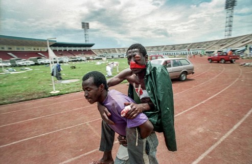 RWA Rwanda Kigali An injured Tutsi refugee who fled to the sports stadium is carried by a man to a