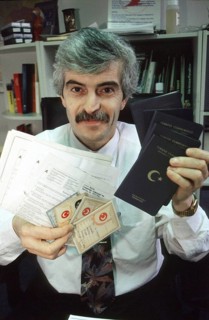 Berlin, DEU, 10.11.1998 -- portrait of Diyap Sarkalli holding Turkish passports and other documents