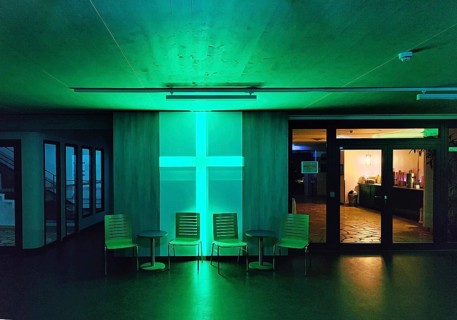 Green illuminated entrance area of the Berlin City Mission at night, Berlin, Germany